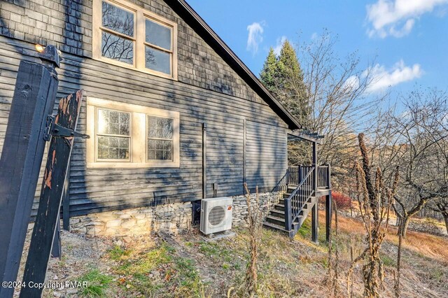 view of home's exterior with ac unit and stairway