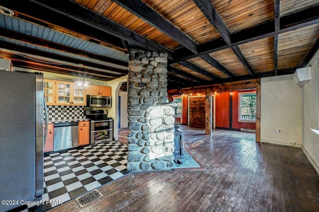 kitchen with visible vents, appliances with stainless steel finishes, an AC wall unit, beamed ceiling, and hardwood / wood-style flooring