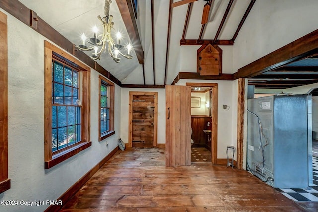 unfurnished room with vaulted ceiling with beams, hardwood / wood-style flooring, baseboards, and a notable chandelier