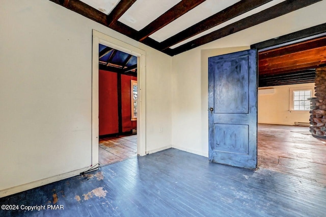 spare room featuring lofted ceiling with beams, a baseboard radiator, baseboards, and wood finished floors