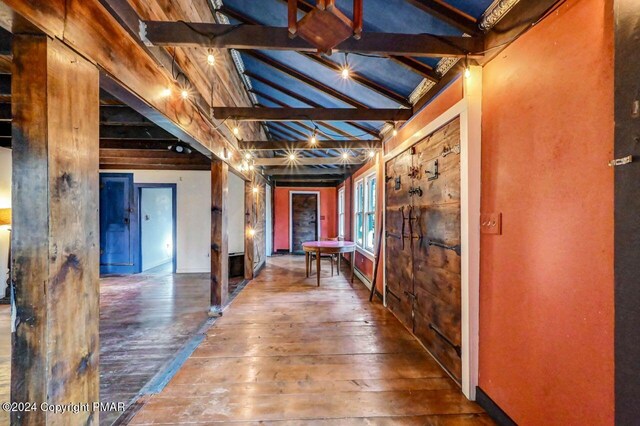 hall featuring vaulted ceiling with beams and hardwood / wood-style flooring