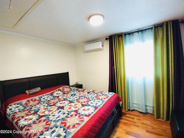 bedroom with ornamental molding, a wall mounted AC, and hardwood / wood-style floors