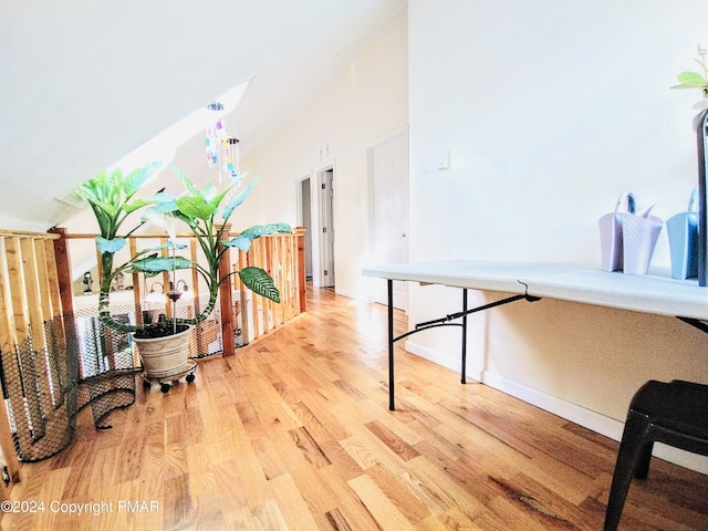 corridor featuring hardwood / wood-style floors and high vaulted ceiling