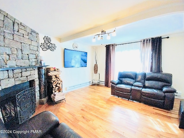 living room featuring baseboard heating, a fireplace, and hardwood / wood-style floors