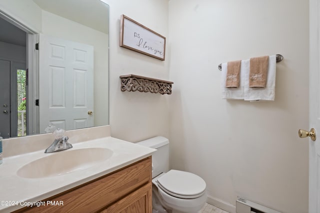 bathroom with vanity, toilet, and baseboard heating