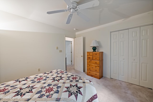 bedroom featuring lofted ceiling, light colored carpet, a closet, and ceiling fan