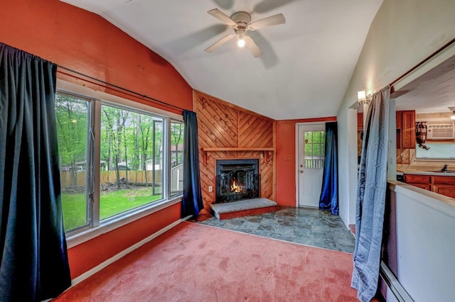 159 Sandstone Dr, Dingmans Ferry, PA 18328 - unfurnished living room featuring vaulted ceiling, healthy amount of natural light, a lit fireplace, ceiling fan, and wood walls