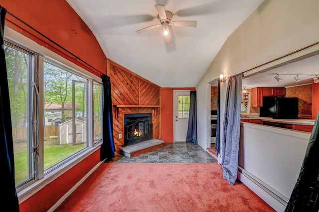 159 Sandstone Dr, Dingmans Ferry, PA 18328 - unfurnished living room featuring baseboard heating, lofted ceiling, light colored carpet, a premium fireplace, and a ceiling fan