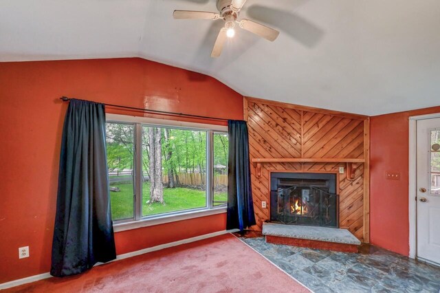 159 Sandstone Dr, Dingmans Ferry, PA 18328 - unfurnished living room with lofted ceiling, ceiling fan, a glass covered fireplace, baseboards, and carpet floors
