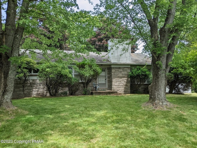 view of front facade with a front yard and stone siding