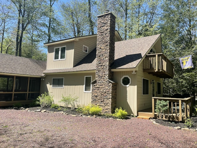 1515 Beech Spring Dr, Pocono Pines, PA 18350 - back of property featuring roof with shingles, a chimney, a balcony, a sunroom, and a deck