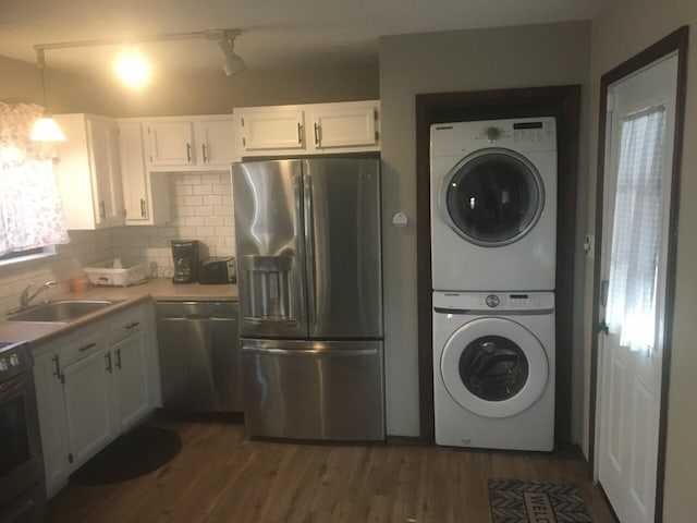 1148 Country Place Dr, Tobyhanna, PA 18466 - kitchen featuring stainless steel appliances, estacked washer and dryer, a sink, white cabinetry, and decorative backsplash