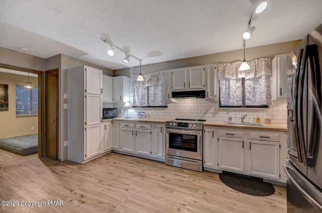 1148 Country Place Dr, Tobyhanna, PA 18466 - kitchen with stainless steel electric range oven, freestanding refrigerator, a sink, under cabinet range hood, and track lighting