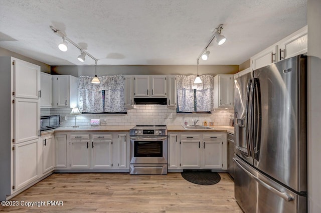 1148 Country Place Dr, Tobyhanna, PA 18466 - kitchen with appliances with stainless steel finishes, rail lighting, a sink, light countertops, and a textured ceiling