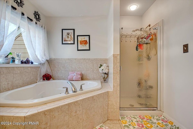 bathroom featuring a stall shower, tile patterned flooring, and a bath