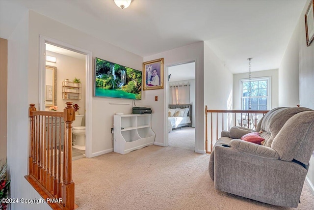 living area featuring light carpet, an inviting chandelier, and baseboards