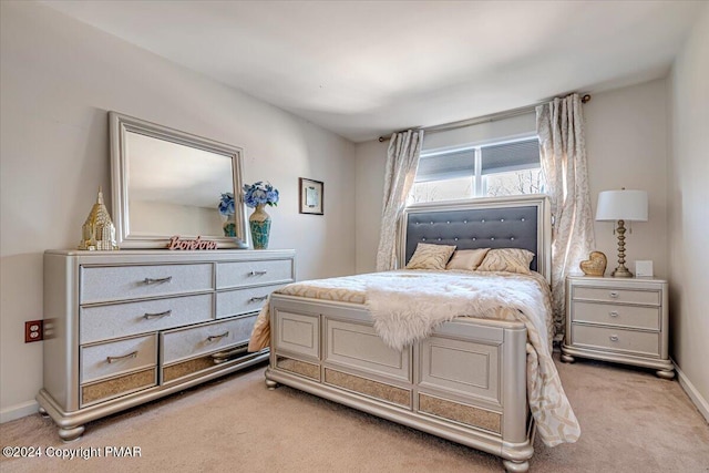 bedroom featuring light carpet and baseboards