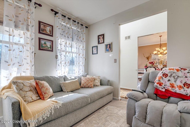 carpeted living room with visible vents and a notable chandelier