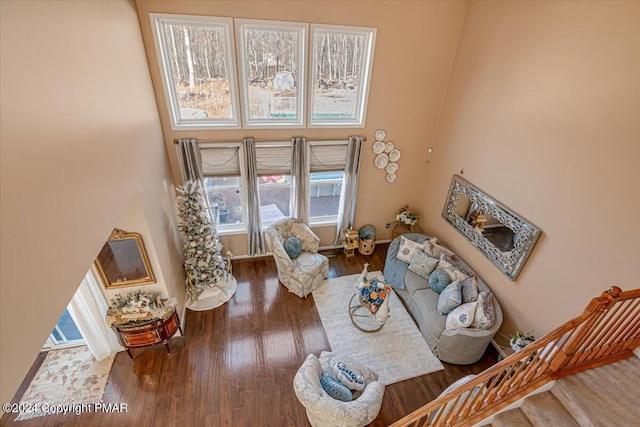 living area with stairway, wood finished floors, and baseboards