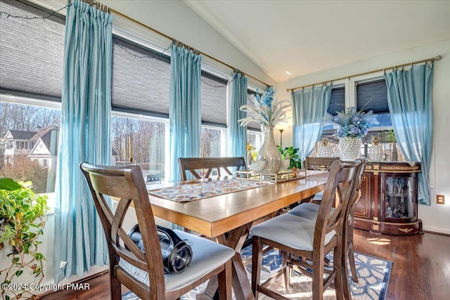 dining area featuring vaulted ceiling and wood finished floors