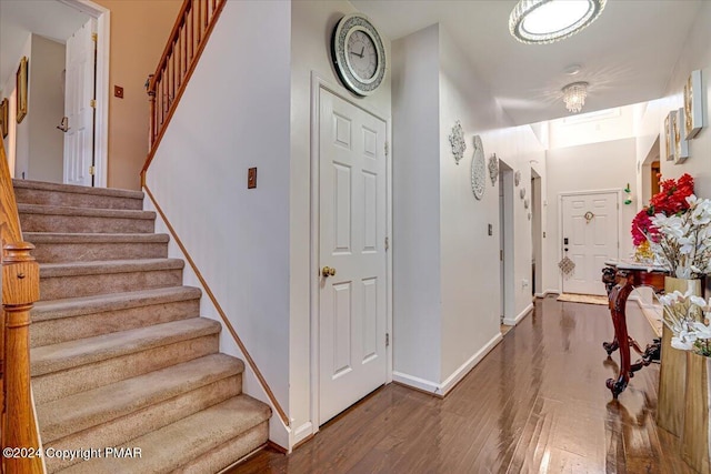 staircase featuring baseboards and wood finished floors