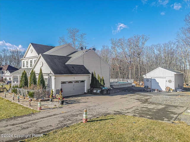 view of side of home with driveway and an outbuilding