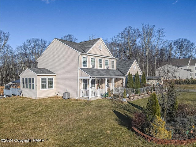 rear view of property with central AC and a lawn