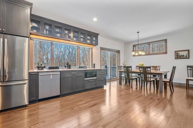 115 Ridgewood Ln, Hawley, PA 18428 - kitchen with appliances with stainless steel finishes, gray cabinetry, light wood-style floors, glass insert cabinets, and a chandelier