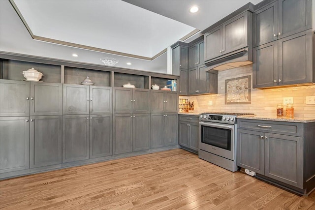 115 Ridgewood Ln, Hawley, PA 18428 - kitchen with open shelves, stainless steel range with gas cooktop, under cabinet range hood, decorative backsplash, and light stone counters