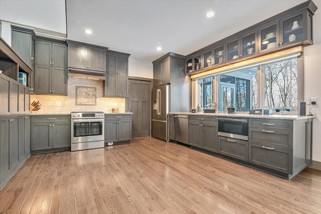 115 Ridgewood Ln, Hawley, PA 18428 - kitchen featuring appliances with stainless steel finishes, light wood-style flooring, backsplash, recessed lighting, and glass insert cabinets
