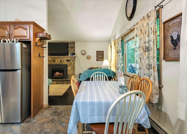 105 Beaver Ln, East Stroudsburg, PA 18301 - dining room with stone finish flooring, a baseboard heating unit, vaulted ceiling, and a fireplace