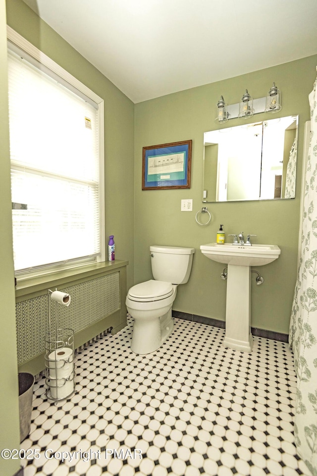 bathroom featuring a sink, toilet, and baseboards