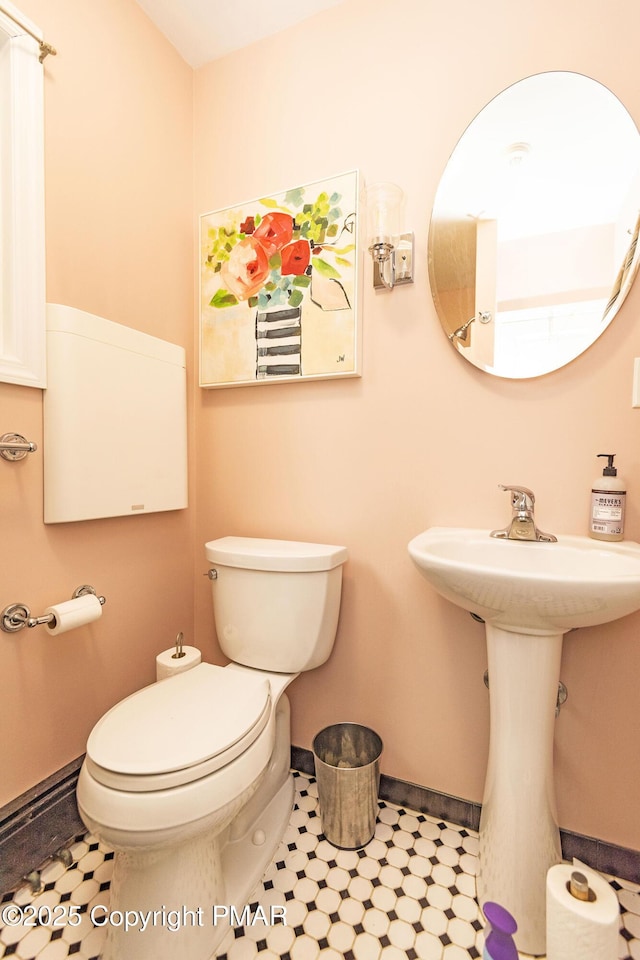 half bathroom with toilet and baseboards