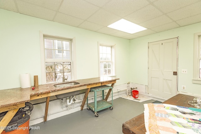 office area featuring a workshop area, a sink, a paneled ceiling, and finished concrete floors