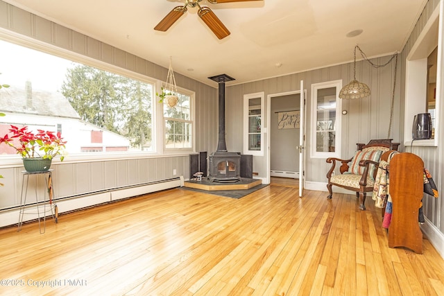 exterior space with a baseboard radiator, a wood stove, and a ceiling fan