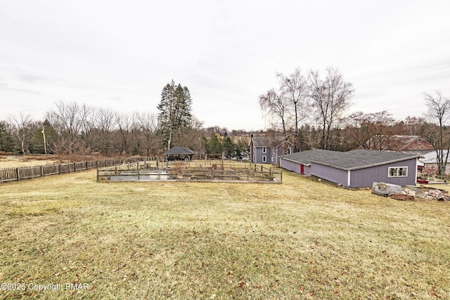 view of yard with a vegetable garden, fence, and a gazebo