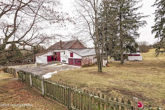 view of yard featuring a garage, driveway, and a fenced front yard