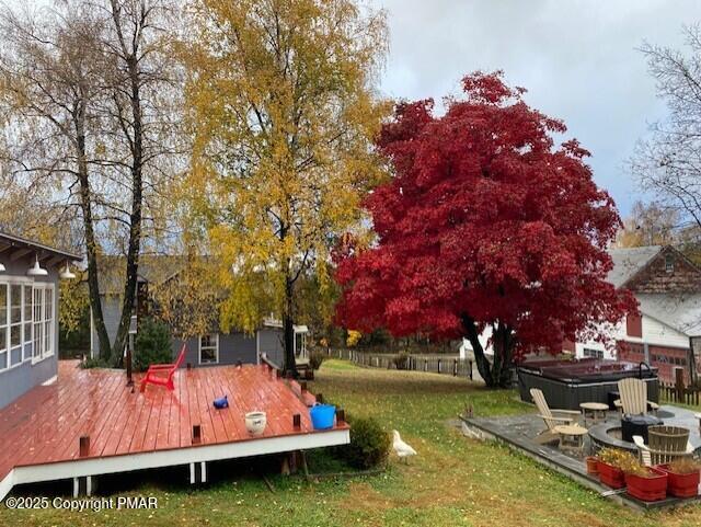 view of yard featuring a hot tub and a deck