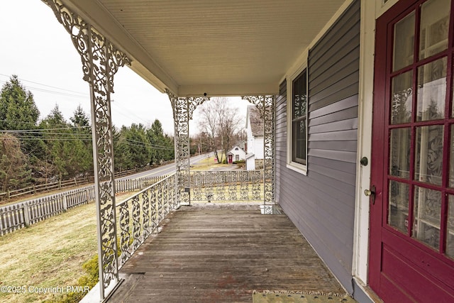 wooden terrace with a porch and fence