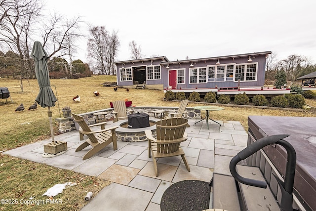 view of patio with a sunroom and a fire pit