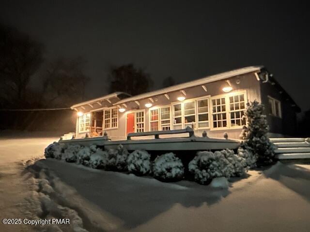 back of house at night featuring driveway