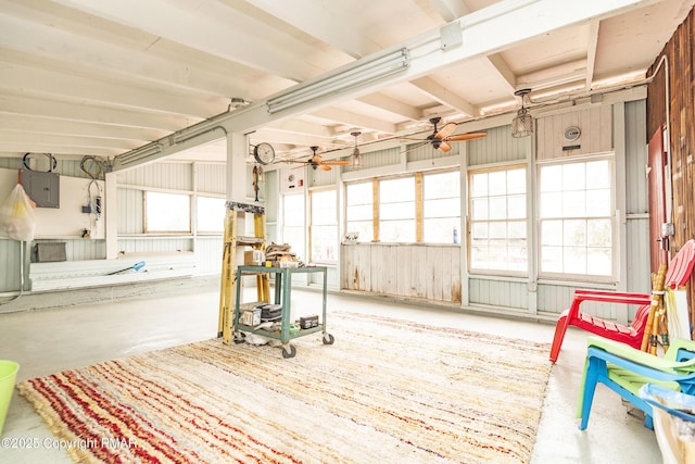 interior space featuring electric panel, concrete floors, and ceiling fan