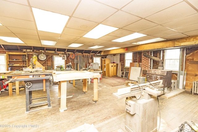 miscellaneous room with a paneled ceiling, wood finished floors, and a workshop area