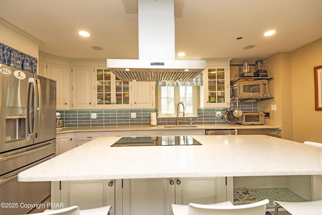 kitchen with sink, appliances with stainless steel finishes, island exhaust hood, white cabinets, and a kitchen island