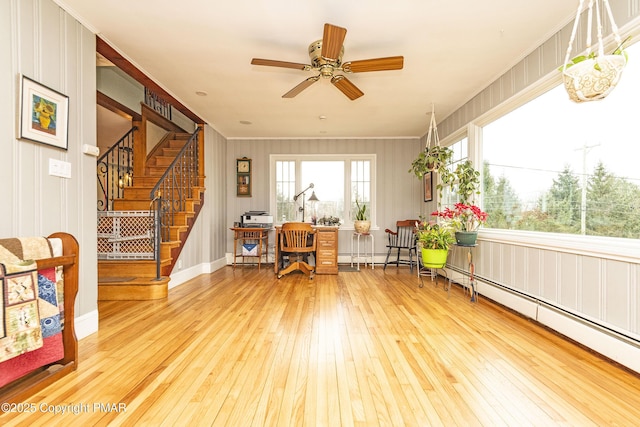 sitting room with ceiling fan, a baseboard radiator, stairs, ornamental molding, and wood-type flooring