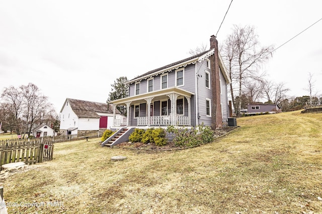 view of front of house featuring a chimney, fence, central air condition unit, a front lawn, and a porch