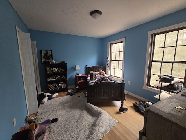 bedroom with wood finished floors and baseboards