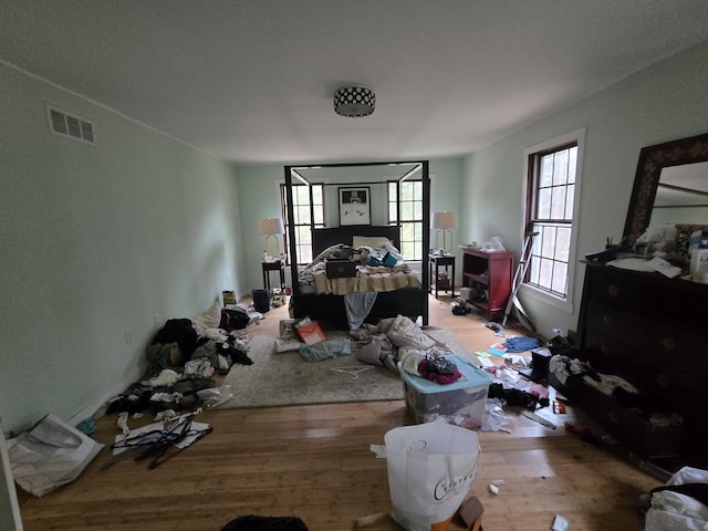 bedroom featuring visible vents and wood finished floors