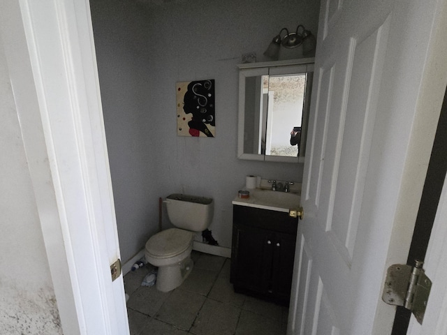 bathroom featuring toilet, vanity, baseboards, and tile patterned floors