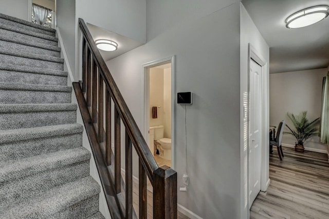 stairway featuring wood finished floors and baseboards